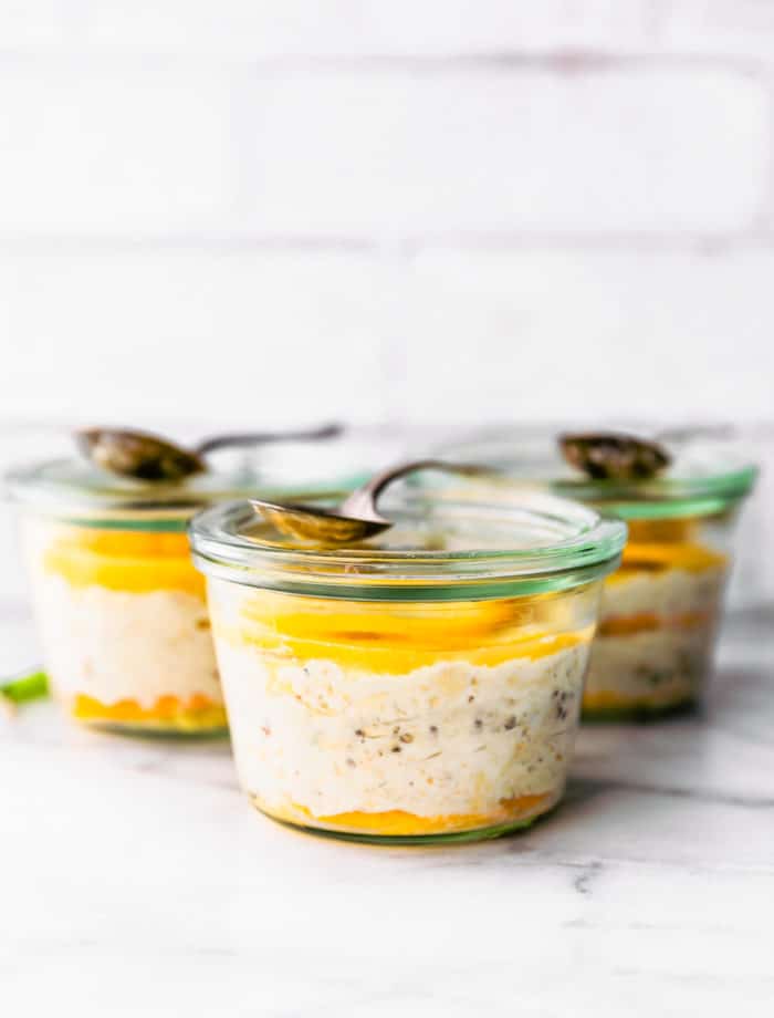 jars of overnight oatmeal with orange slices. Spoon on top of jar