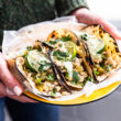 woman holding platter of green chile turkey tacos