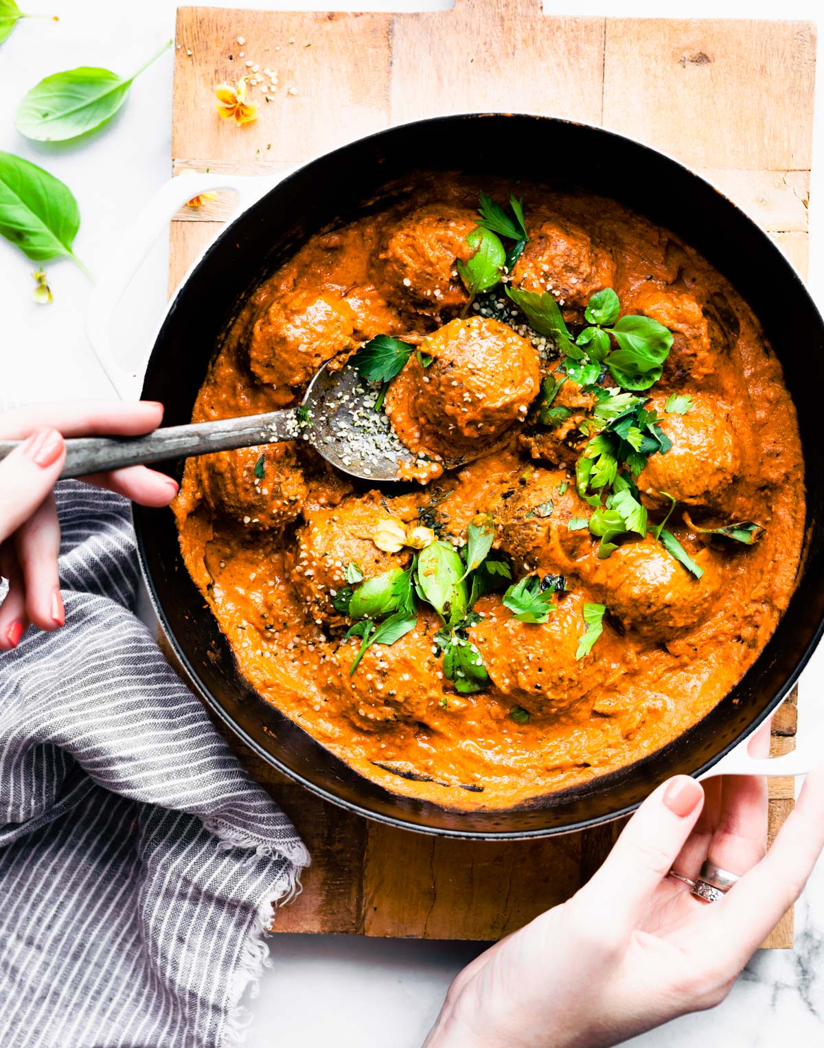 vegan mushroom meatballs in a skillet with one meatball being scooped up with a spoon