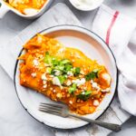 2 spicy enchiladas on plate with fork