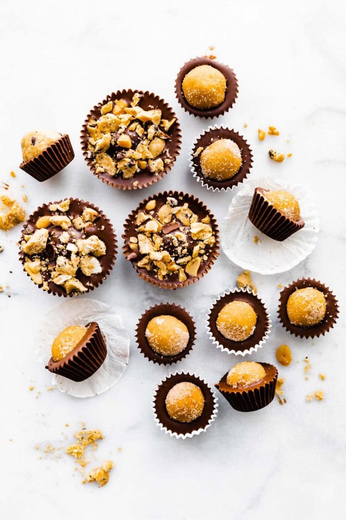 vegan edible cookie dough chocolate cups, some topped with nuts