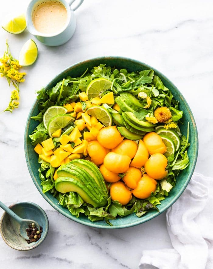 bowl of healthy fruit salad with pieces of mango avocado and cantaloupe