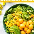 bowl of healthy fruit salad with pieces of mango avocado and cantaloupe with title in white and orange above