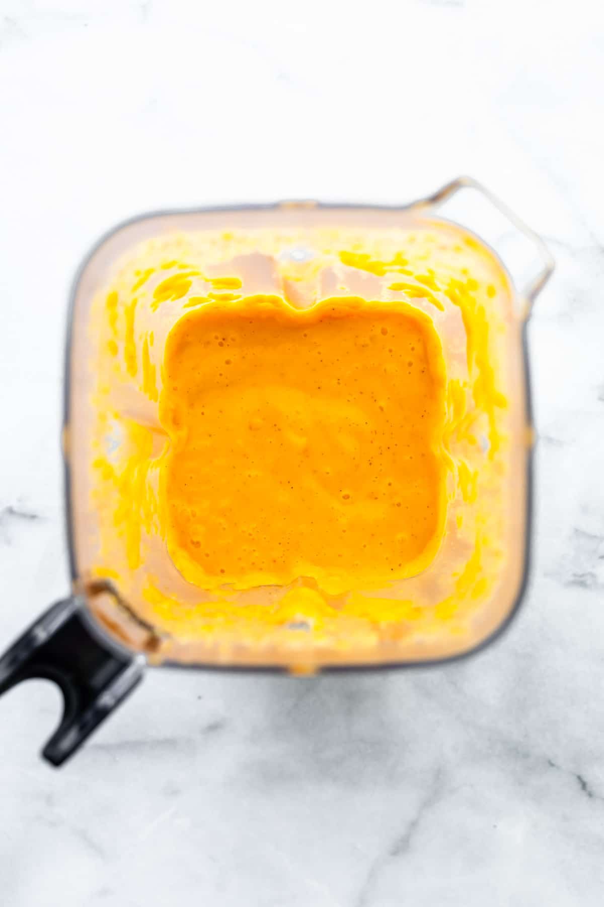 overhead image of yellow chicken marinade in a blender