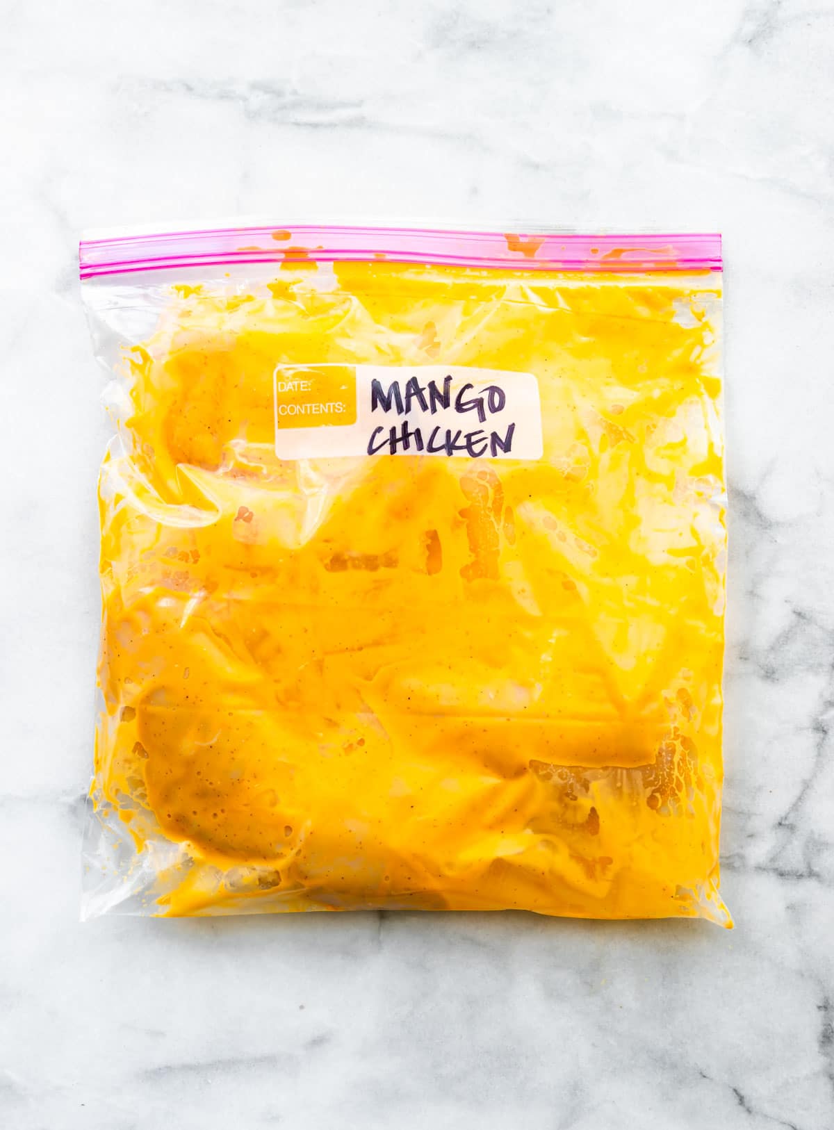 mango chicken marinating in zip top plastic bag