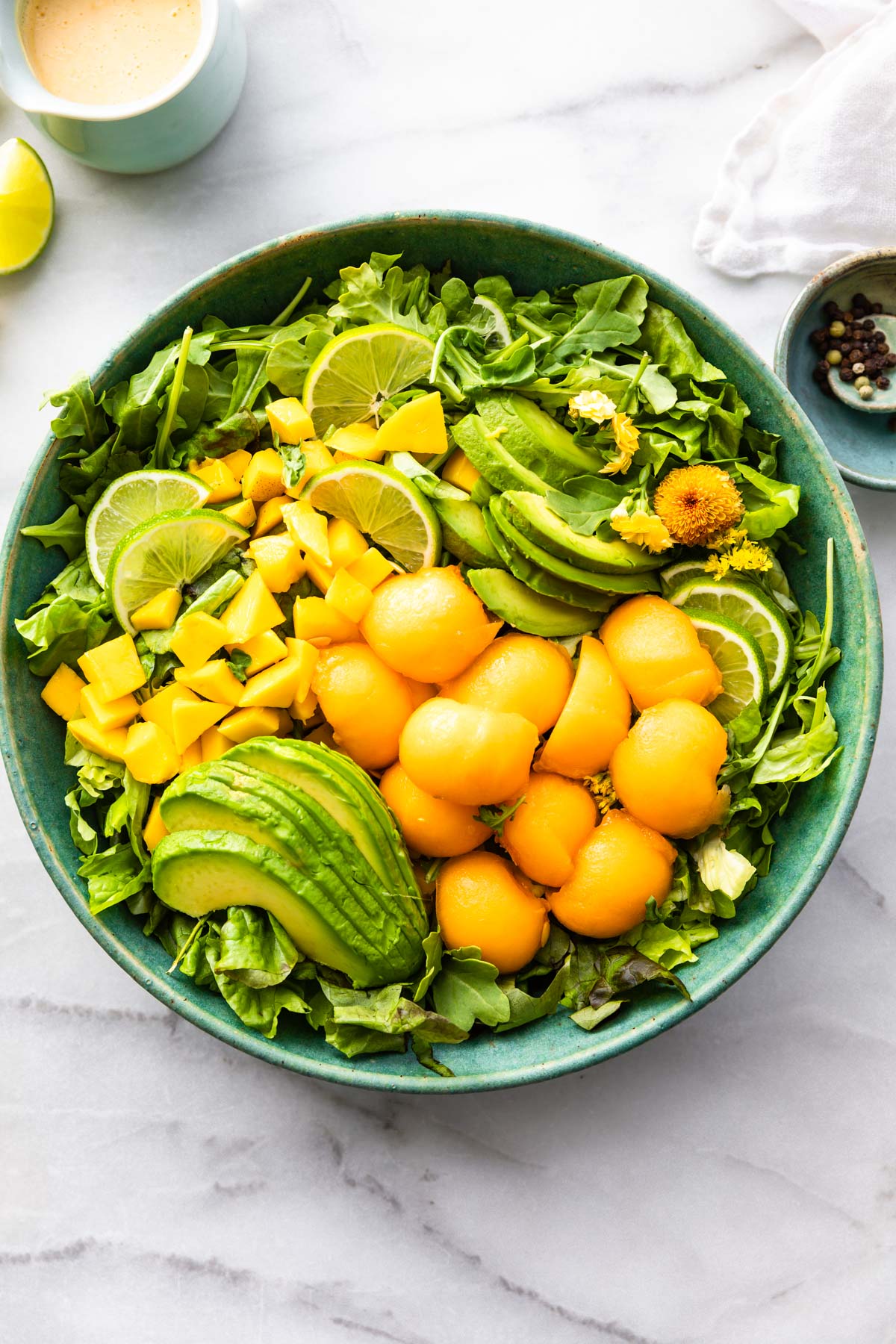 bowl of healthy fruit salad with pieces of mango avocado and cantaloupe.