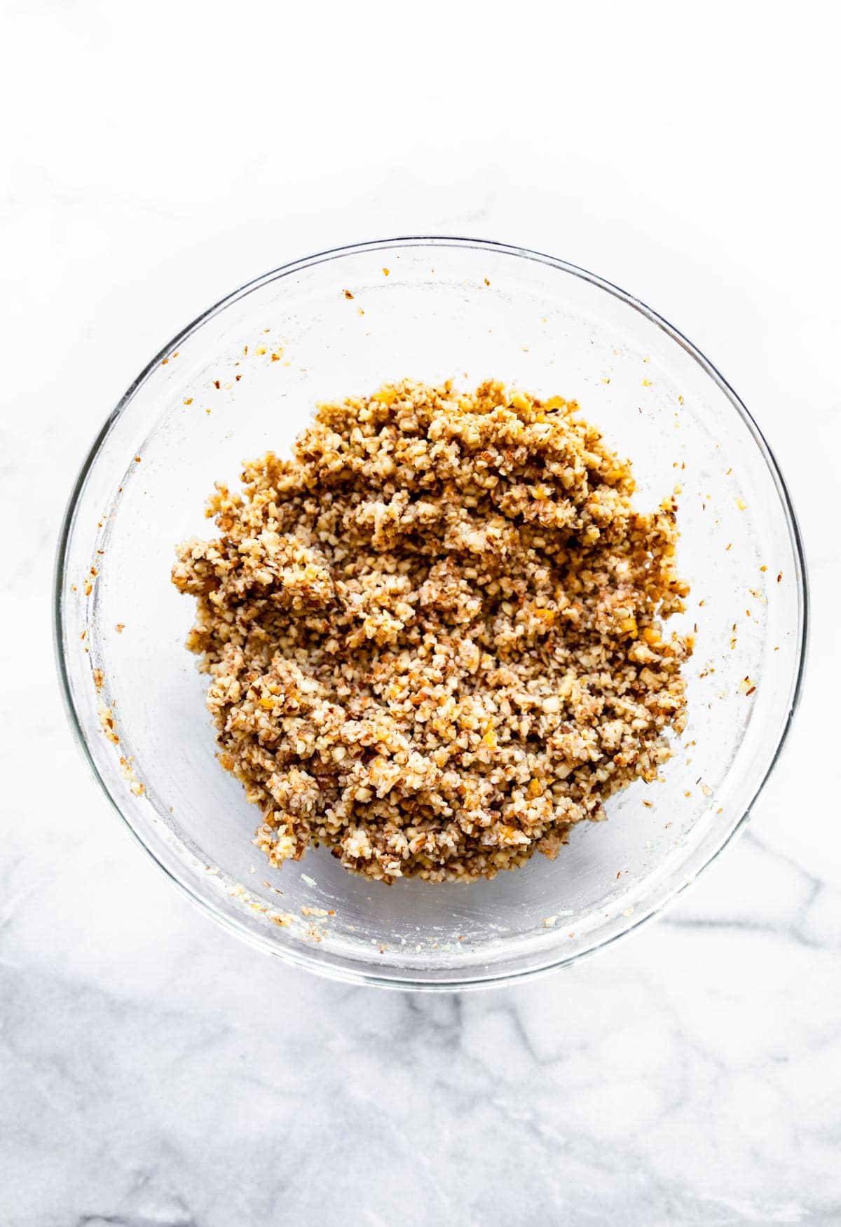 nuts, dried mango, protein powder, and spices in a bowl to make healthy protein bars