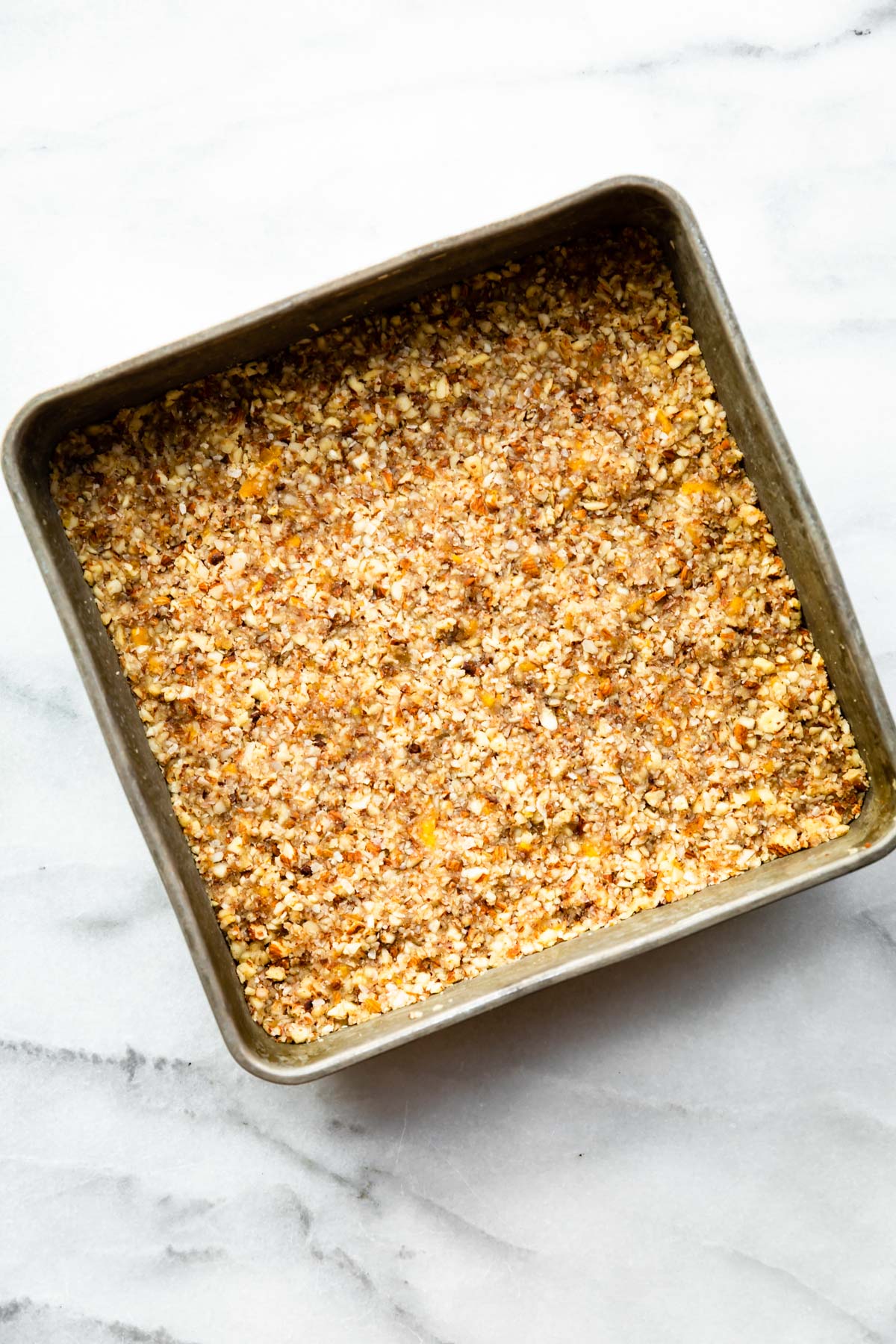 no bake paleo protein bar mixture in an 8 x 8-inch baking pan