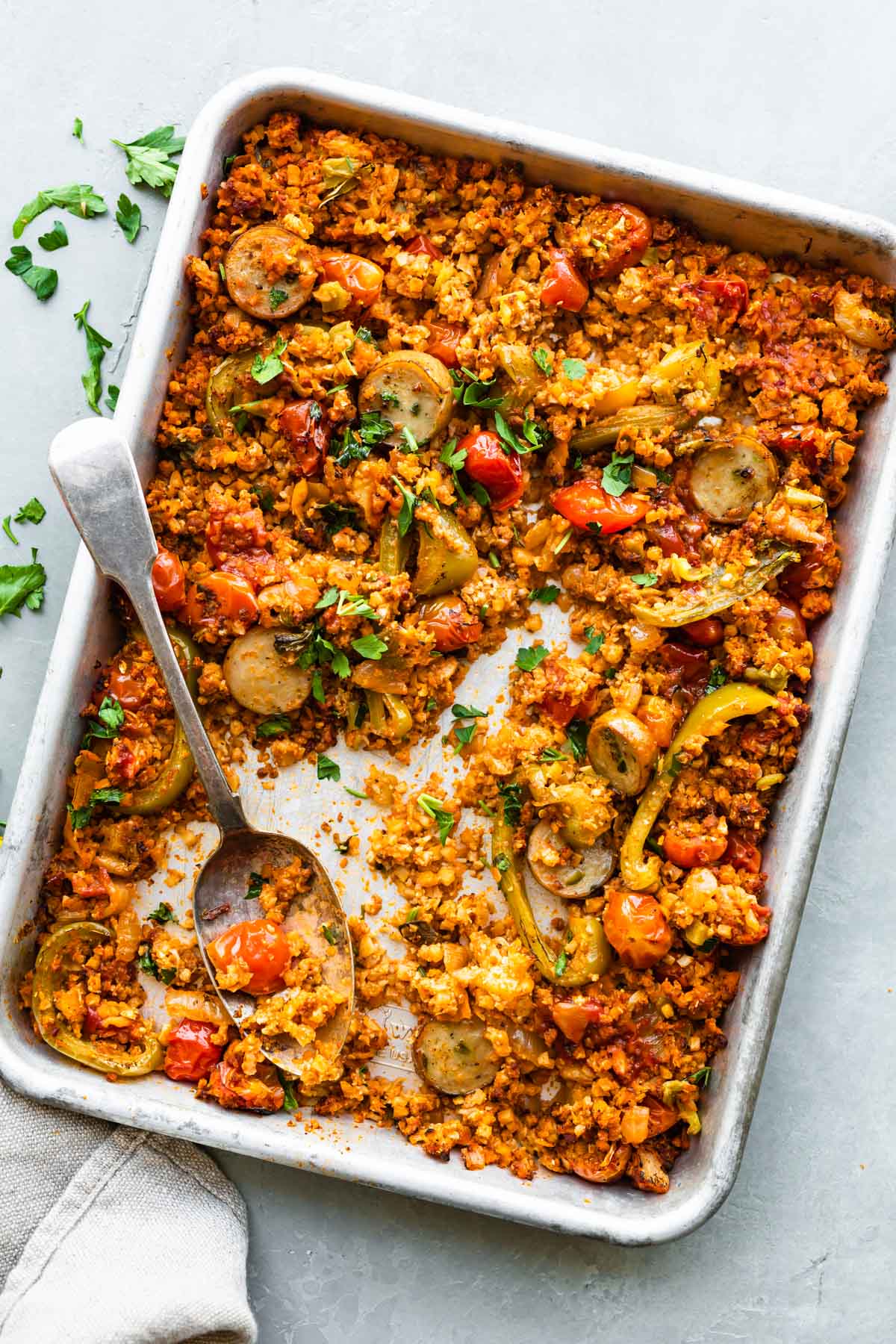 overhead photo: Serving spoon on baking sheet with Mexican cauliflower rice