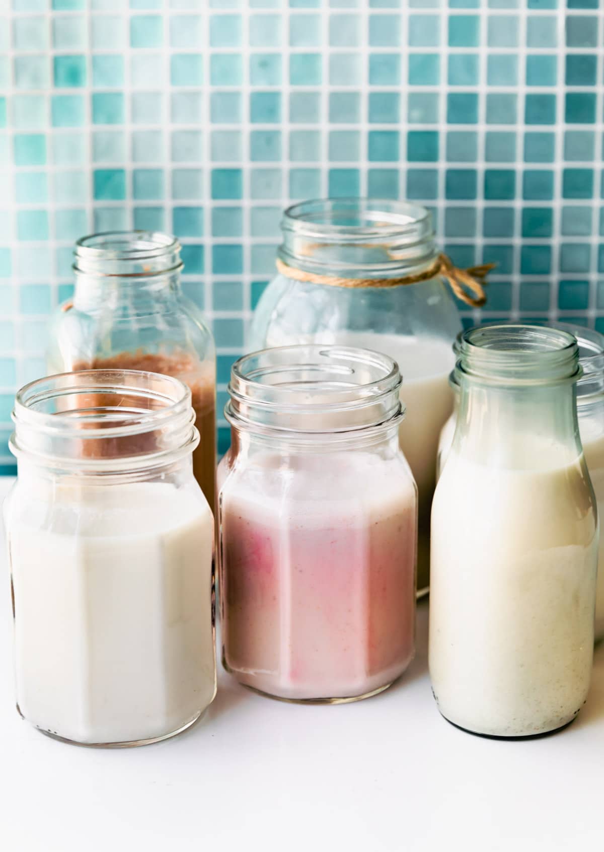 Side image of homemade dairy-free milks in milk jars.