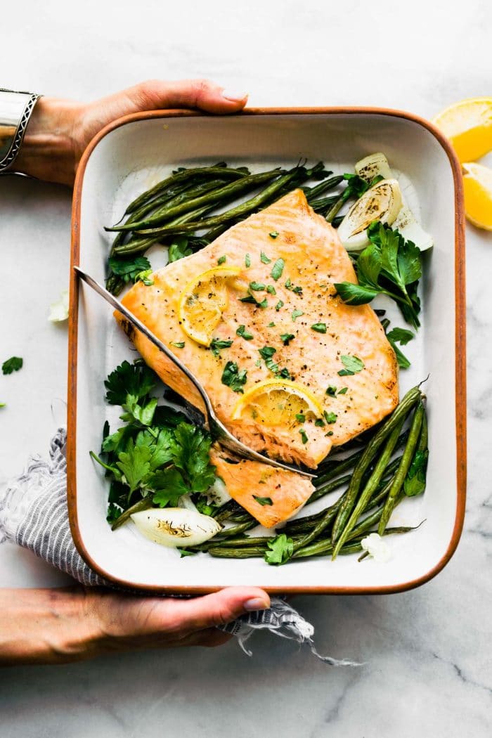 overhead photo: maple mustard baked salmon in white baking dish with French green beans