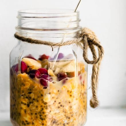 healthy cranberry-pumpkin overnight oats in mason jar with a spoon