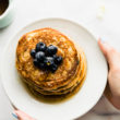 overhead photo: plated stack of vegan protein pancakes topped with fresh blueberries