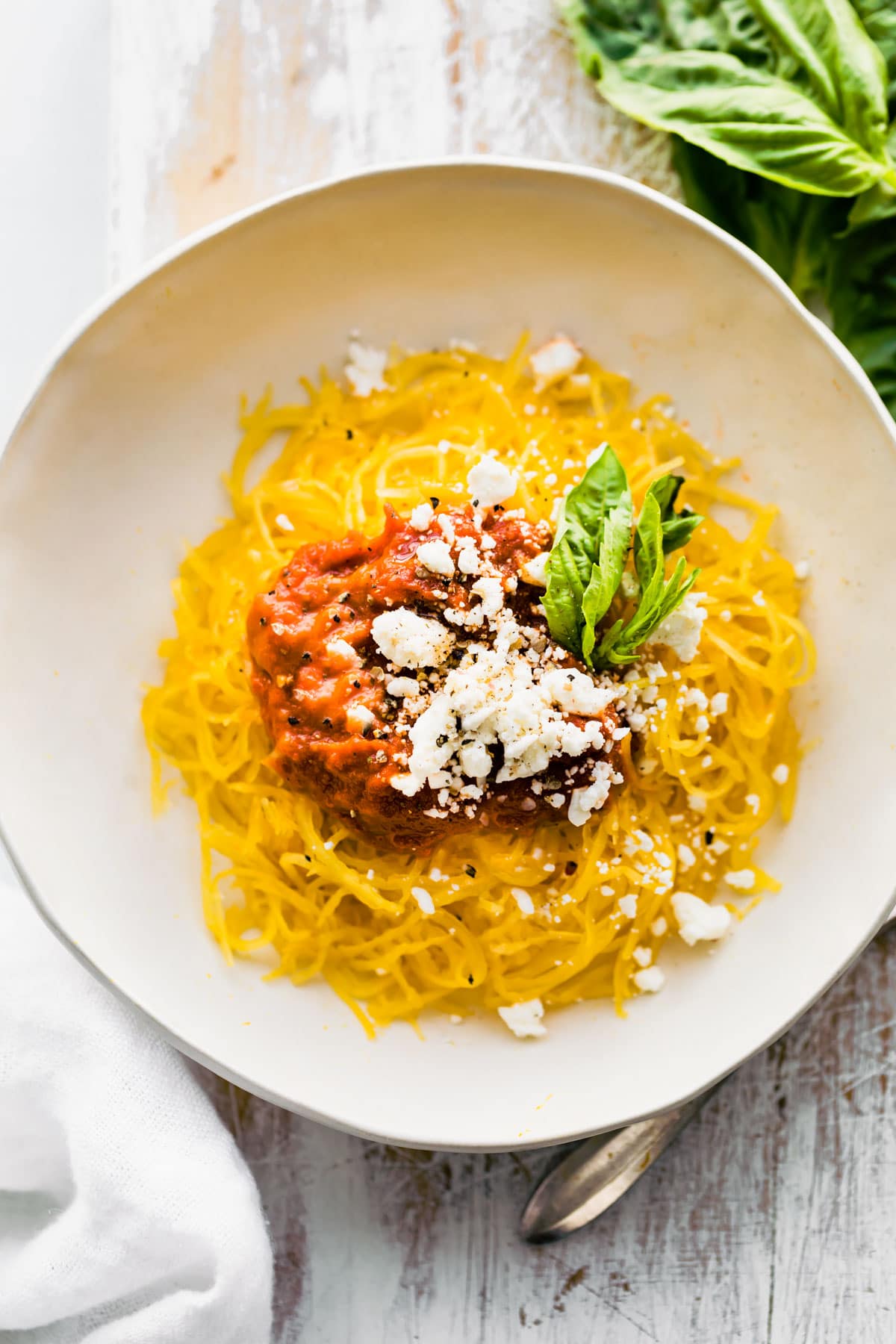 plate of Instant Pot spaghetti squash pasta with nomato sauce and dairy free Parmesan cheese.