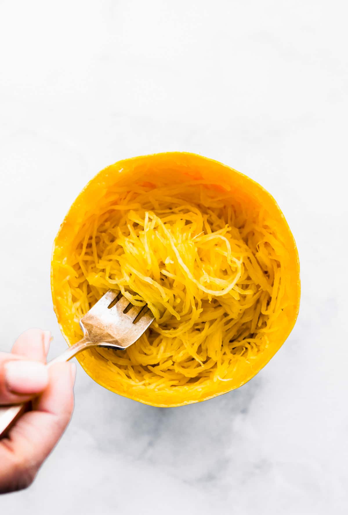 overhead: using fork to remove strands of cooked spaghetti squash