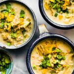 overhead: 3 bowls of Instant Pot White Chicken Chili garnished with fresh cilantro and scallions