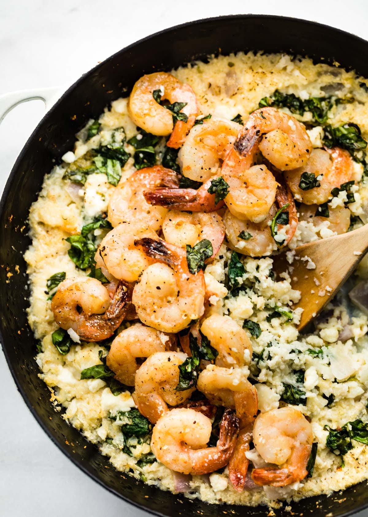 skillet shrimp dinner in pan with wooden spoon
