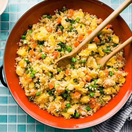 overhead image: two serving spoons in skillet of homemade healthy fried rice