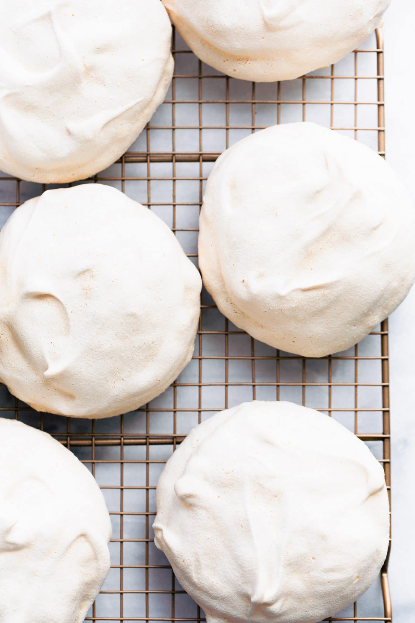 Overhead image of baked pavlovas on a cooling rack.