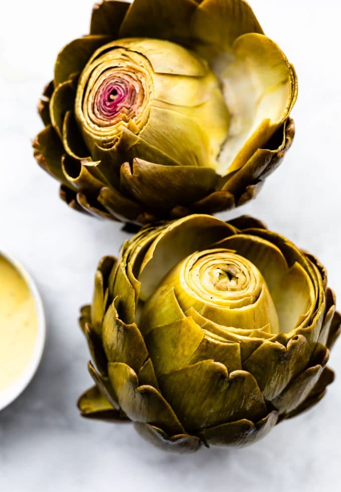 Two cooked artichokes.