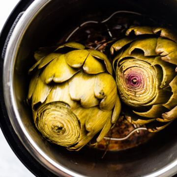 overhead photos of cooked artichokes in an instant pot. Pressure cooked artichokes with lid off the pot