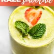 kale smoothie in glass with mint and strawberry on top. Title of recipe on top with red banner and white text