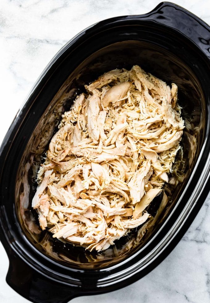 Overhead view shredded chicken in slow cooker