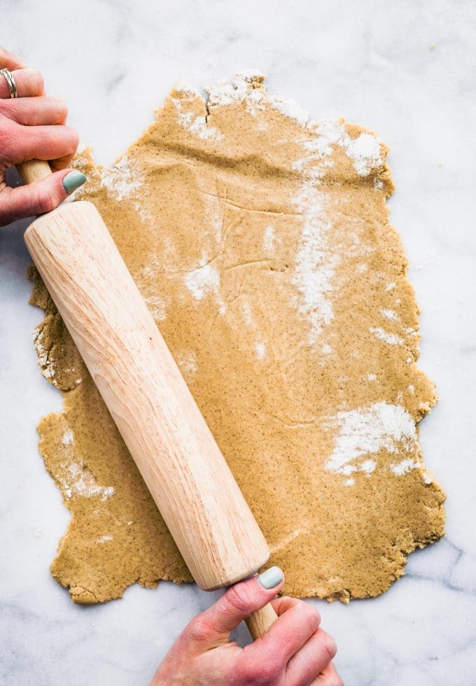 Overhead image of two hands rolling out graham cracker dough.