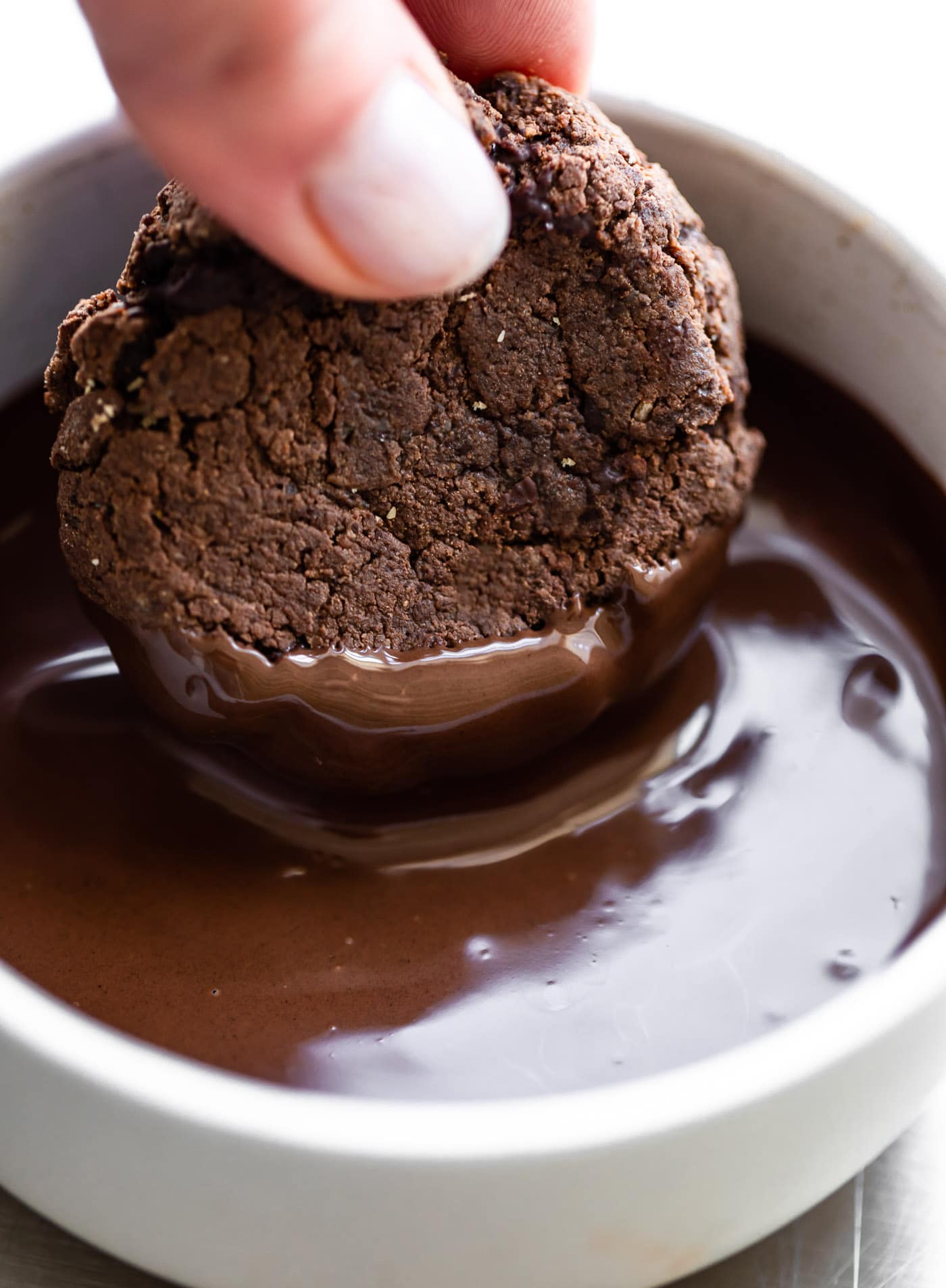 Image of dipping chocolate protein cookies in melted chocolate.
