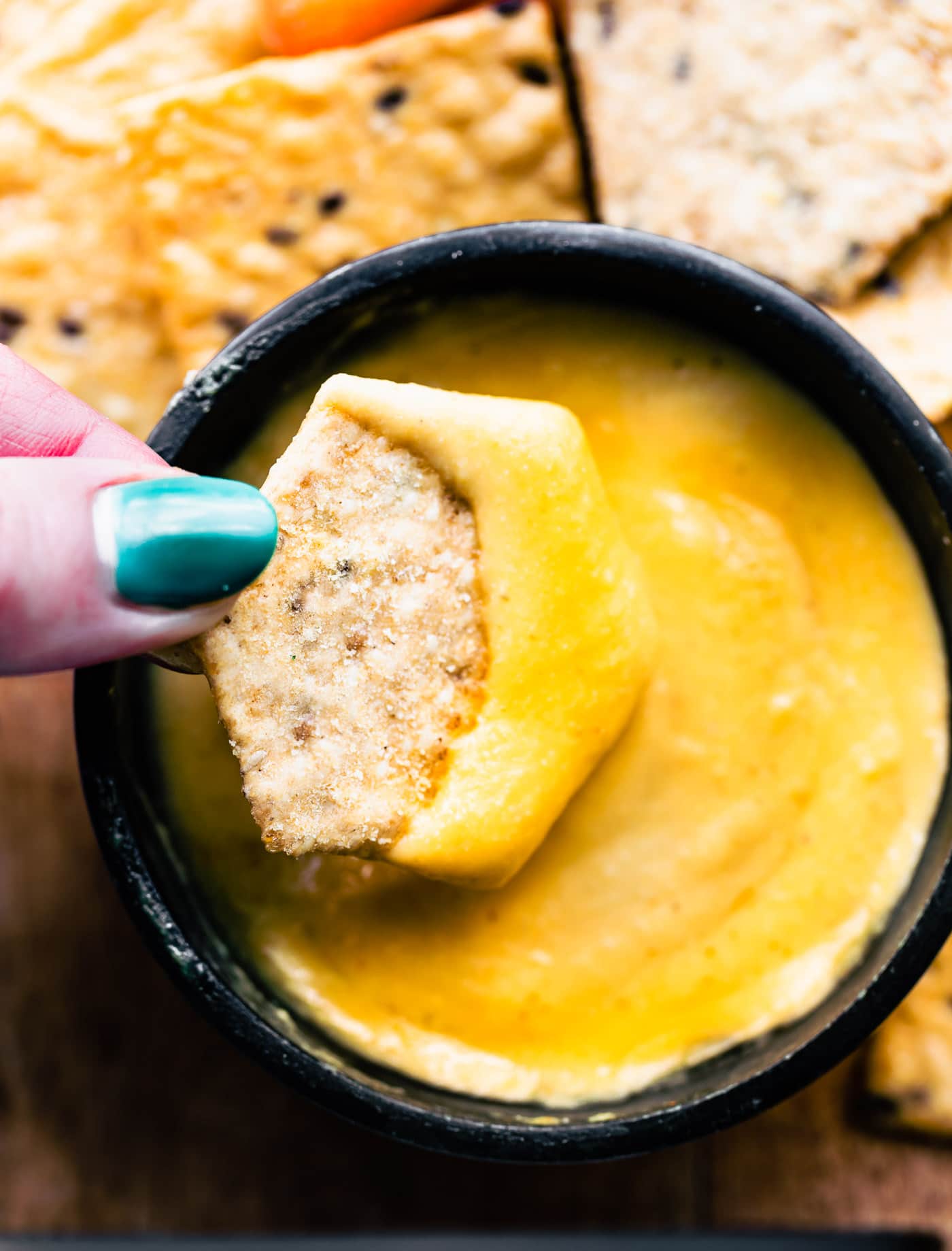 Close up image of vegan mac and cheese sauce being used as a dip.