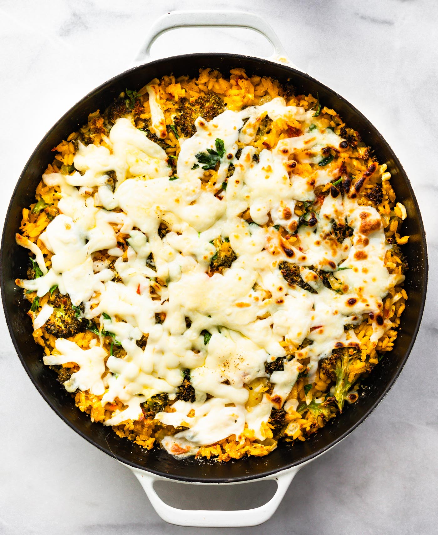 Healthy broccoli and cheese casserole topped with shredded cheese in a baking dish
