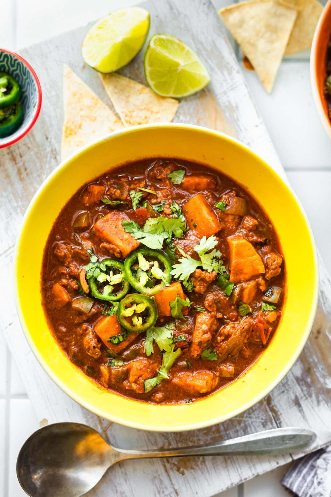 sweet potato turkey chili in a bowl topped with cilantro and jalapeno