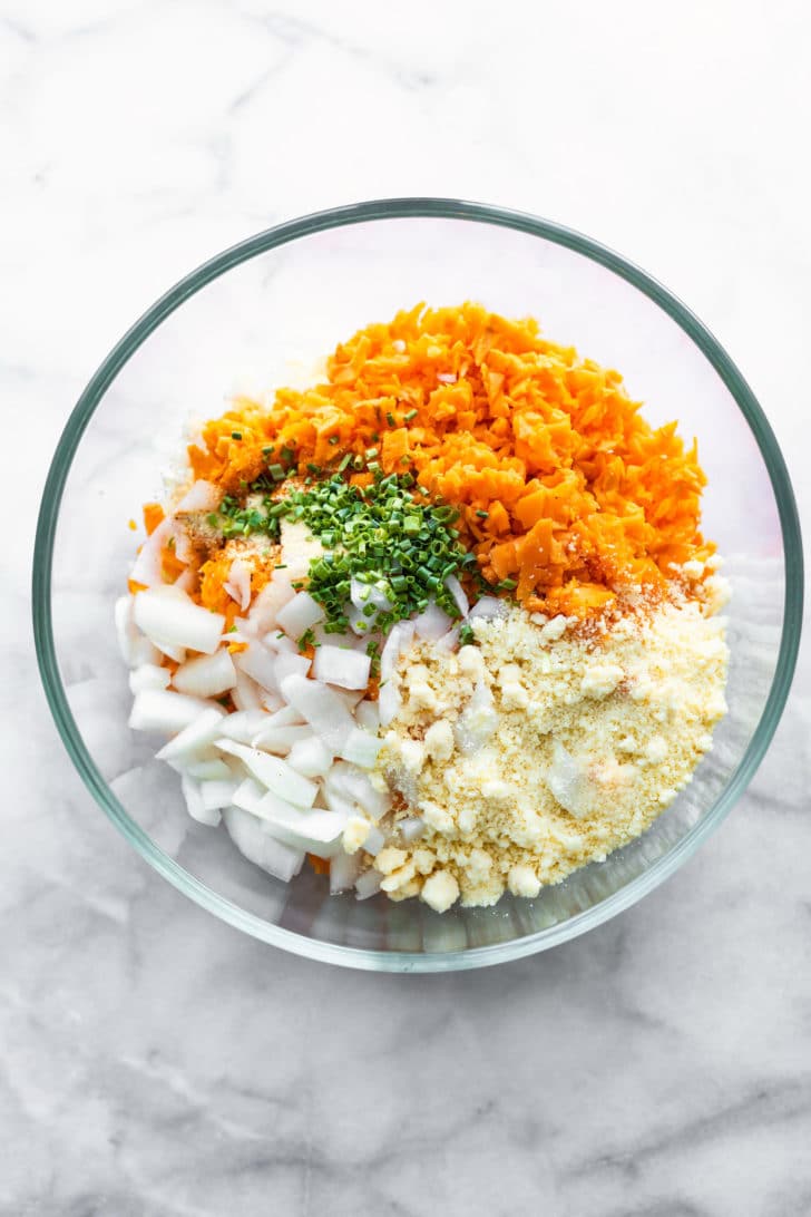 sweet potato tot ingredients in a clear mixing bowl