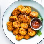 sweet potato tots in a white bowl with ketchup on the side