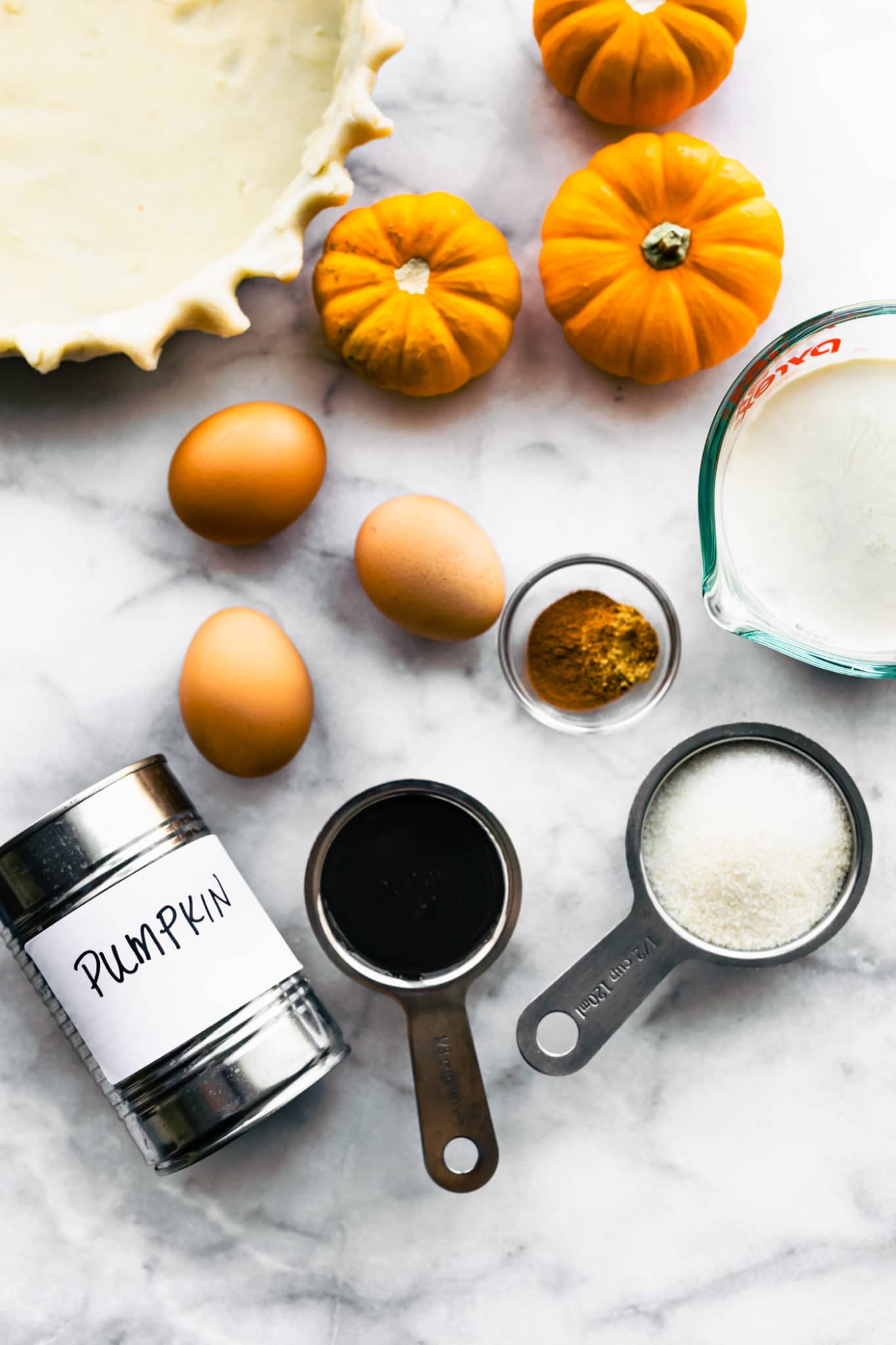 Ingredients for Gluten Free Pumpkin Pie arranged together in small bowls and measuring cups.