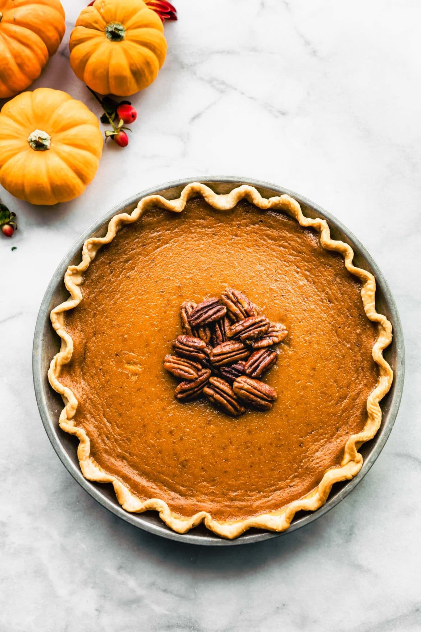 Whole gluten-free pumpkin pie with pecans on top