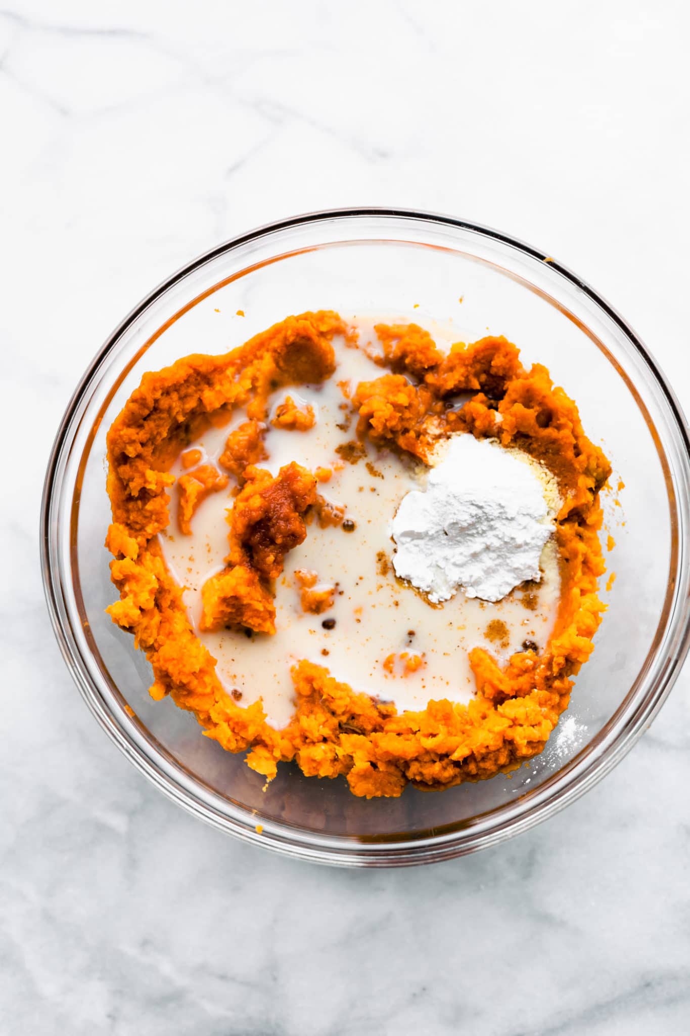 Pureed sweet potatoes in a blender with non-dairy milk and other ingredients for a vegan sweet potato casserole