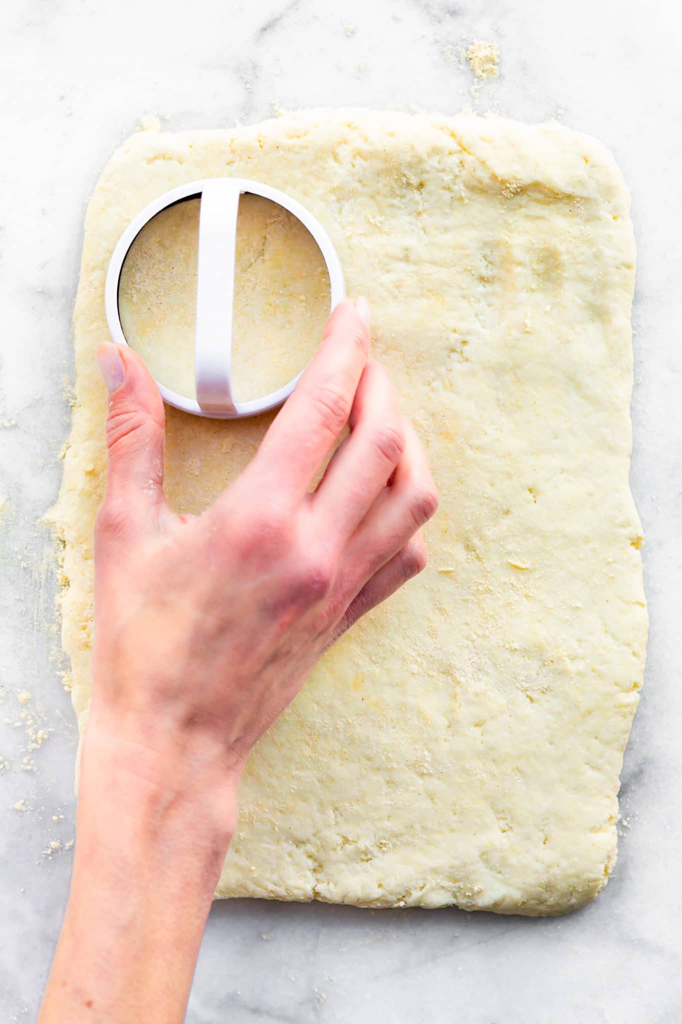 a sheet of dough being cut for gluten free biscuits