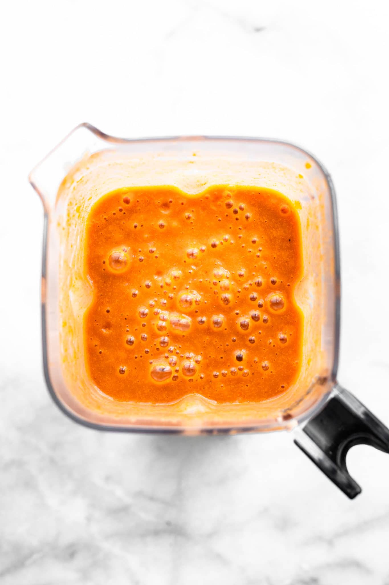 tomato crab bisque base being pureed in a blender