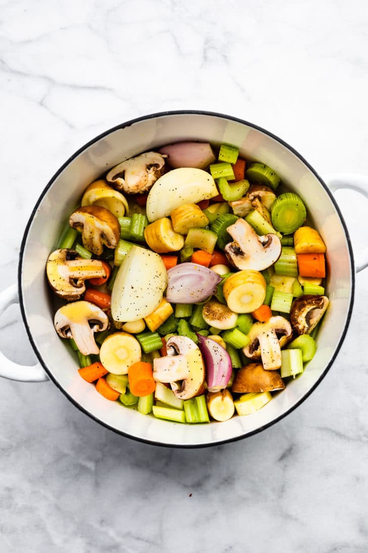 overhead image of chopped vegetables in a pot to create vegetable broth