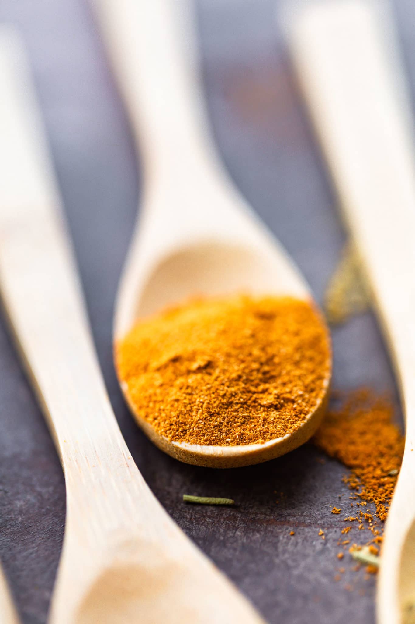 a close up image of turmeric in a wooden spoon
