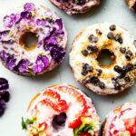vegan baked donuts topped with three different flavor options including chocoalte, strawberry, and vanilla
