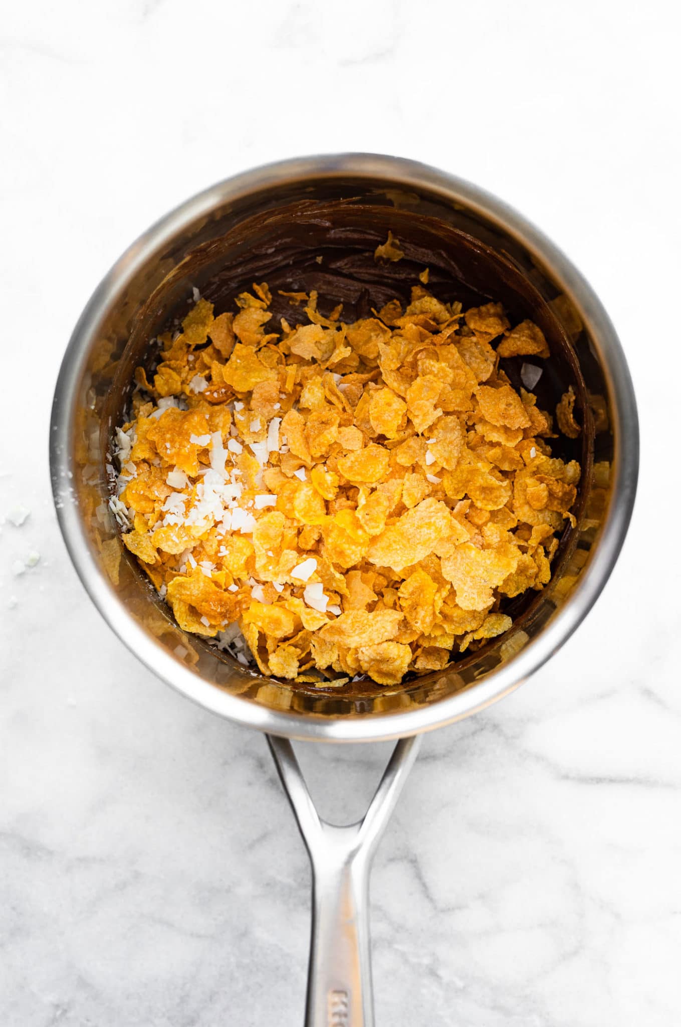 a saucepan full of cornflake cereal for chocolate peanut butter cornflake cookies
