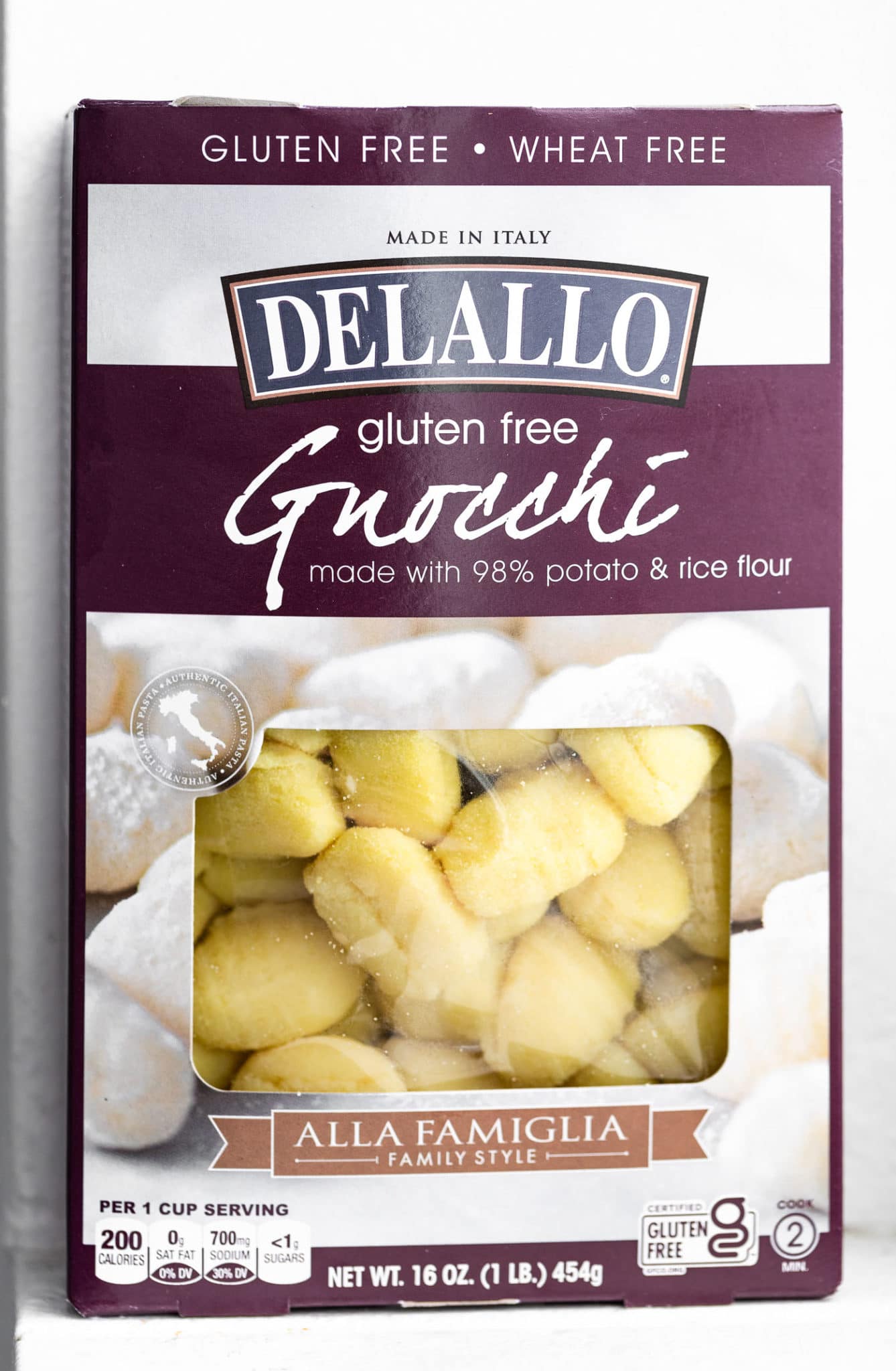 a box of delallo gluten free gnocchi with a cut out near the bottom showing the uncooked pieces of gnocchi