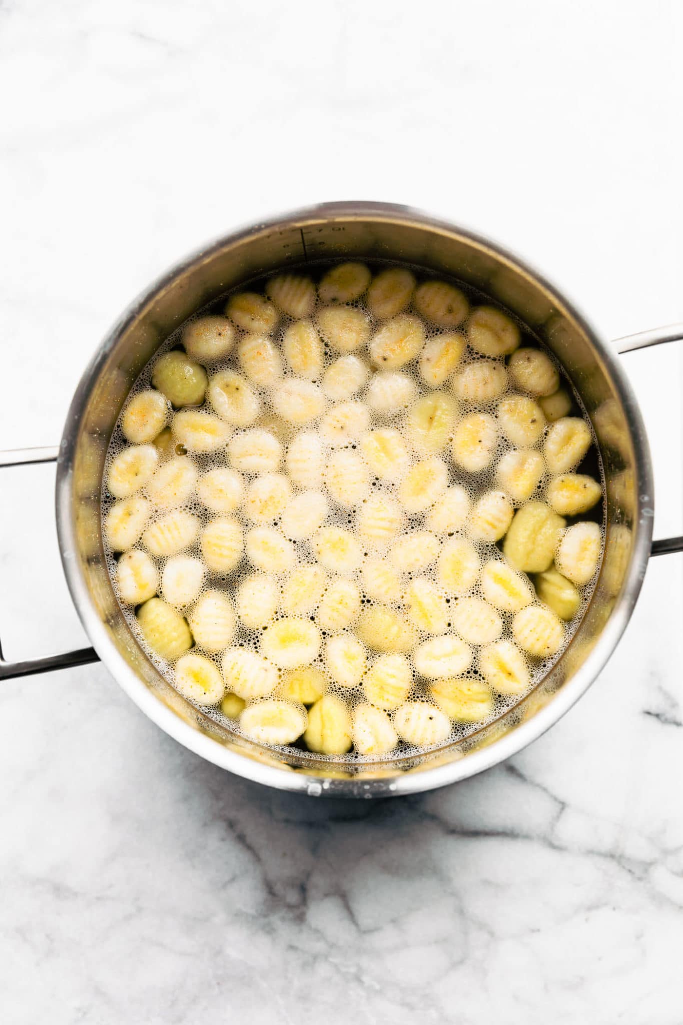 overhead image of gltuen free gnocchi in a saucepan submerged in water