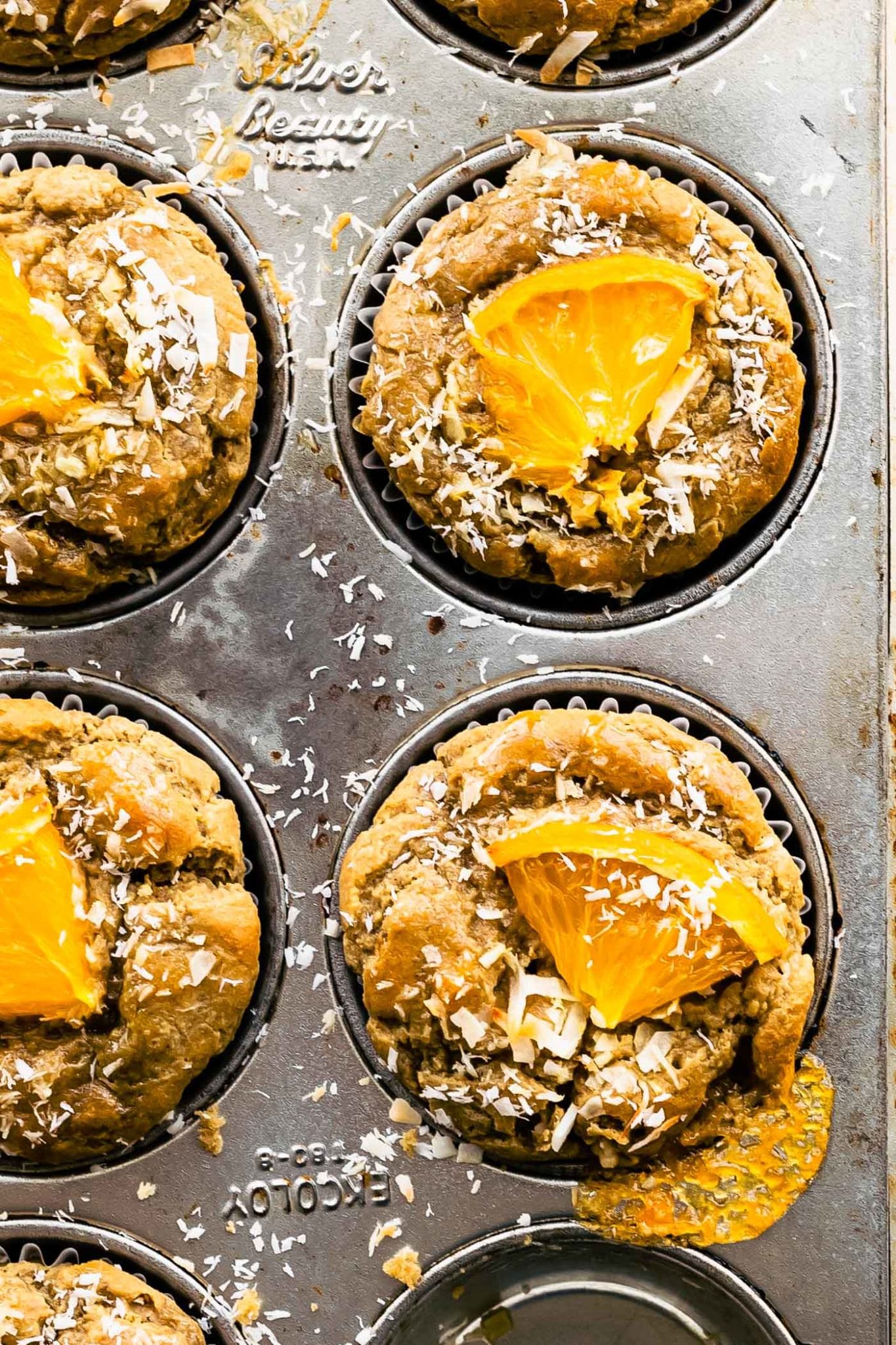 overhead shot of orange coconut oatmeal muffins in muffins tin'