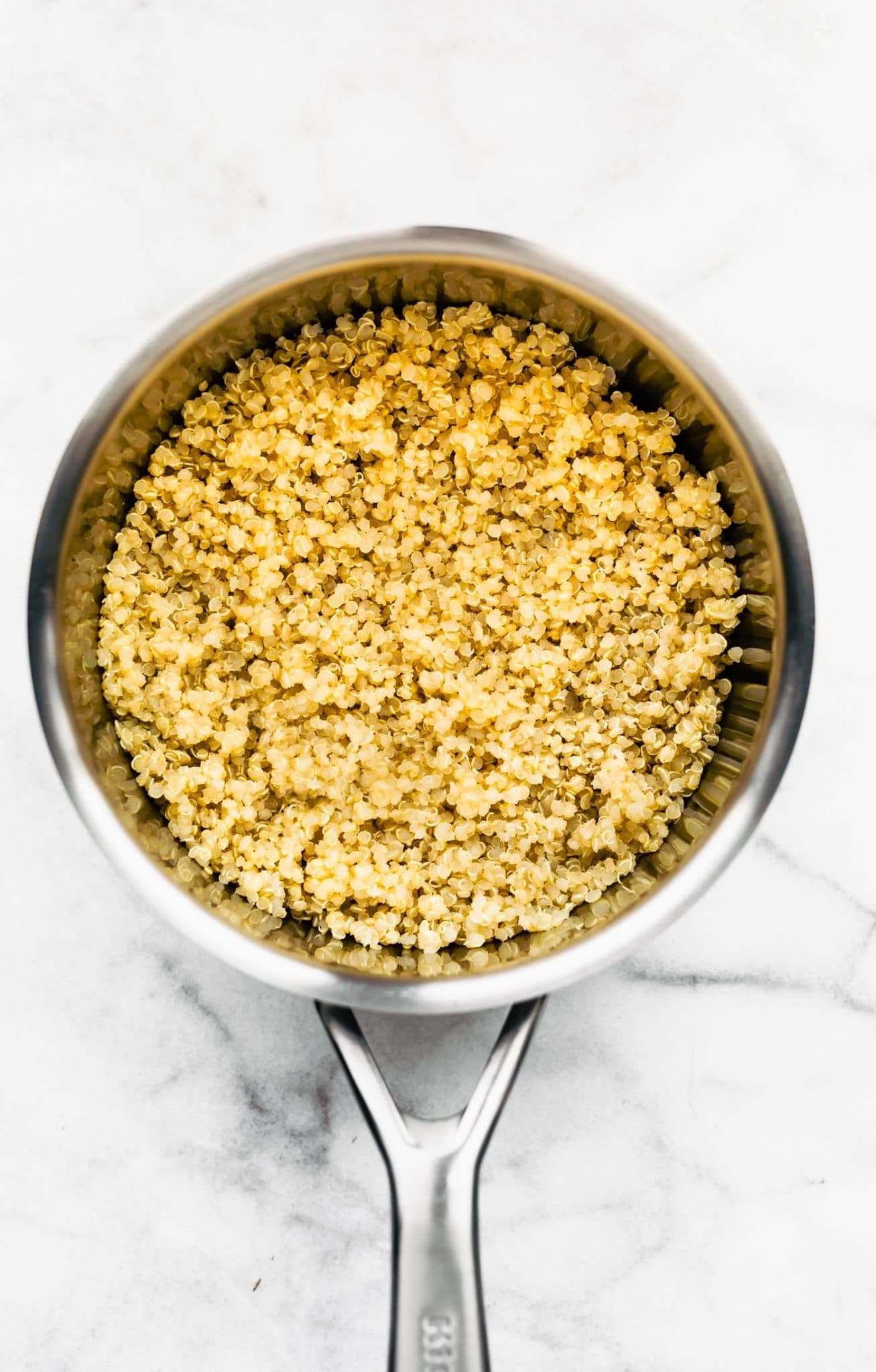 a sauce pan full of cooked gluten free quinoa grains