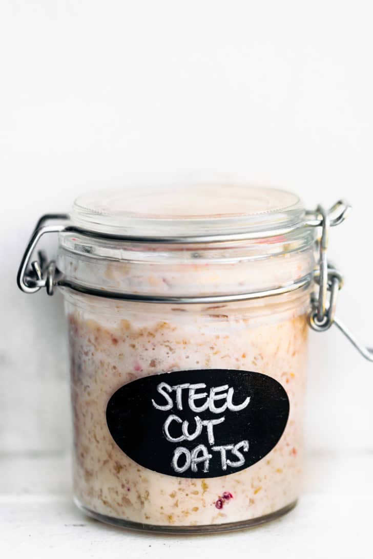 a glass jar full of overnight oats labeled steel cut oats