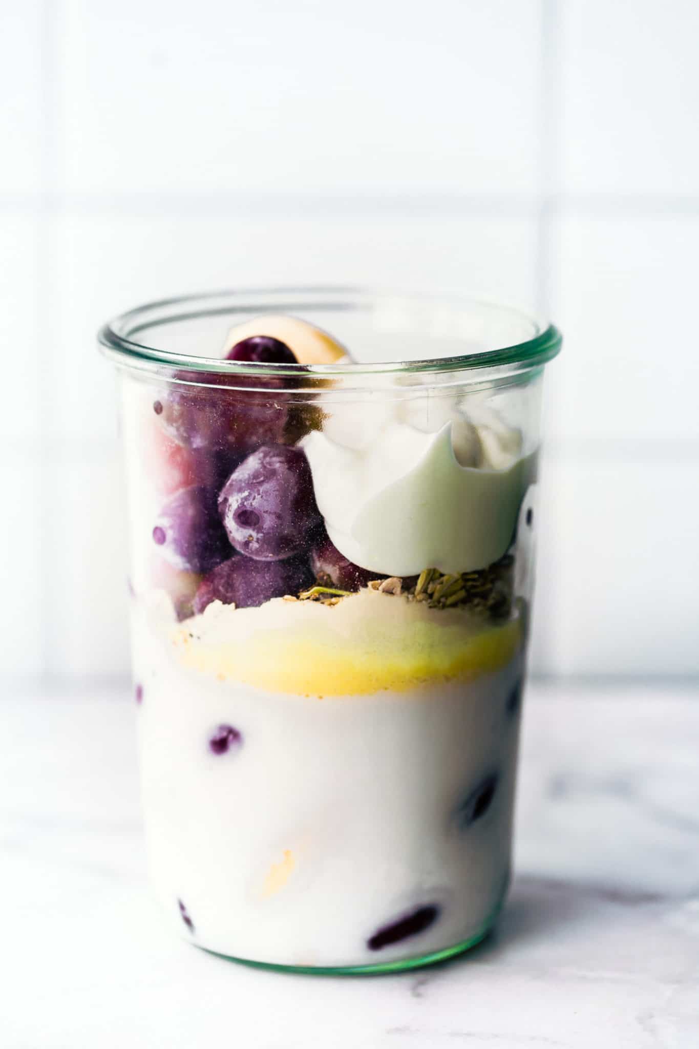 non-dairy milk, frozen bananas, frozen grapes, non-dairy yogurt, and chia seeds in a glass jar to make a frozen grape smoothie recipe