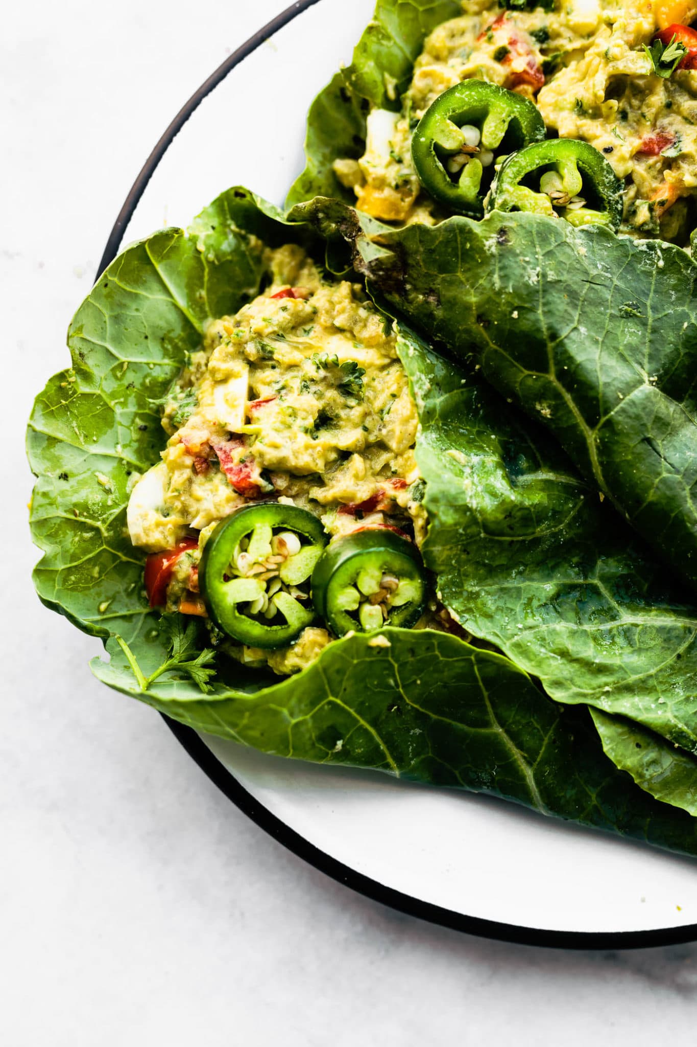 close up image of Mexican avocado egg salad wraps in collard greens